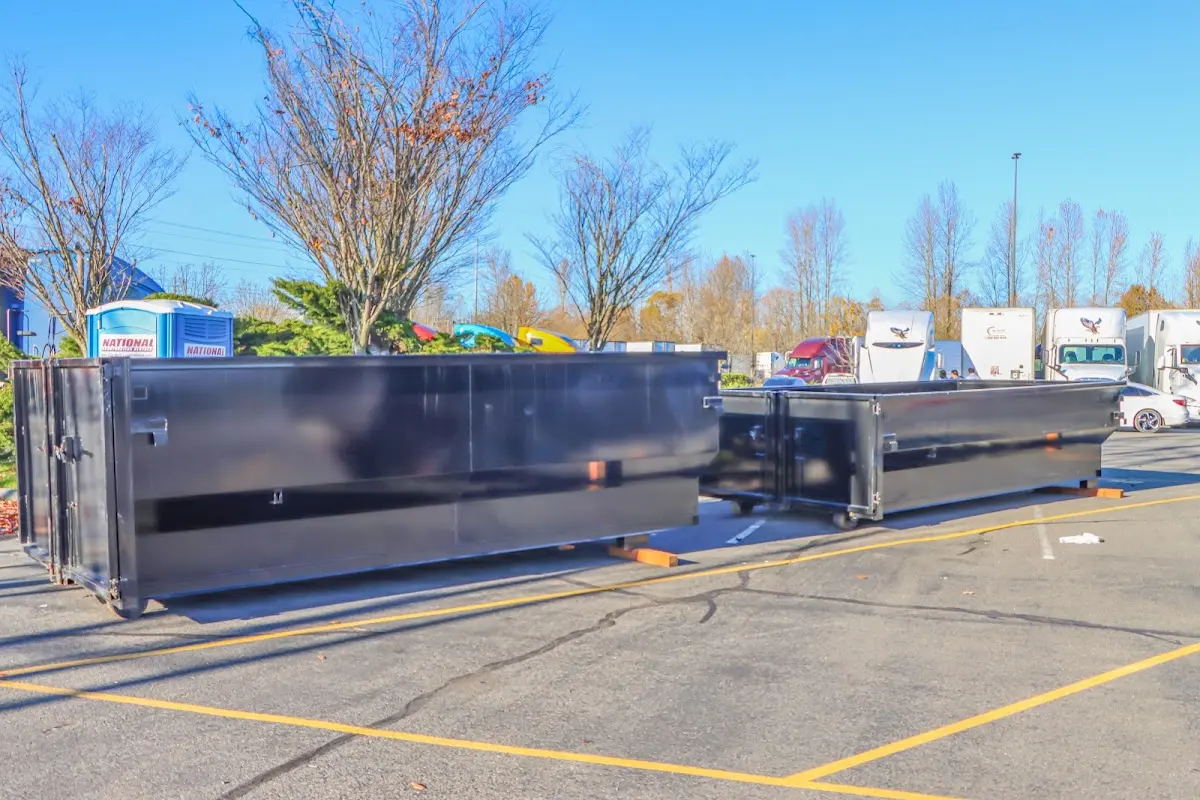 Professional dumpster rental service with roll-off container on residential driveway in Forsyth